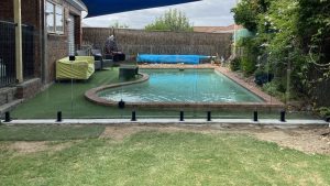 Frameless glass pool fencing with black spigots